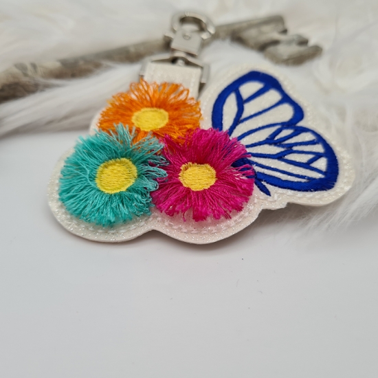 Taschenanhänger / Taschenbaumler Schmetterling mit Blumen weiß/blau